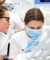 Photo shows two female students at a dental unit in the university clinic